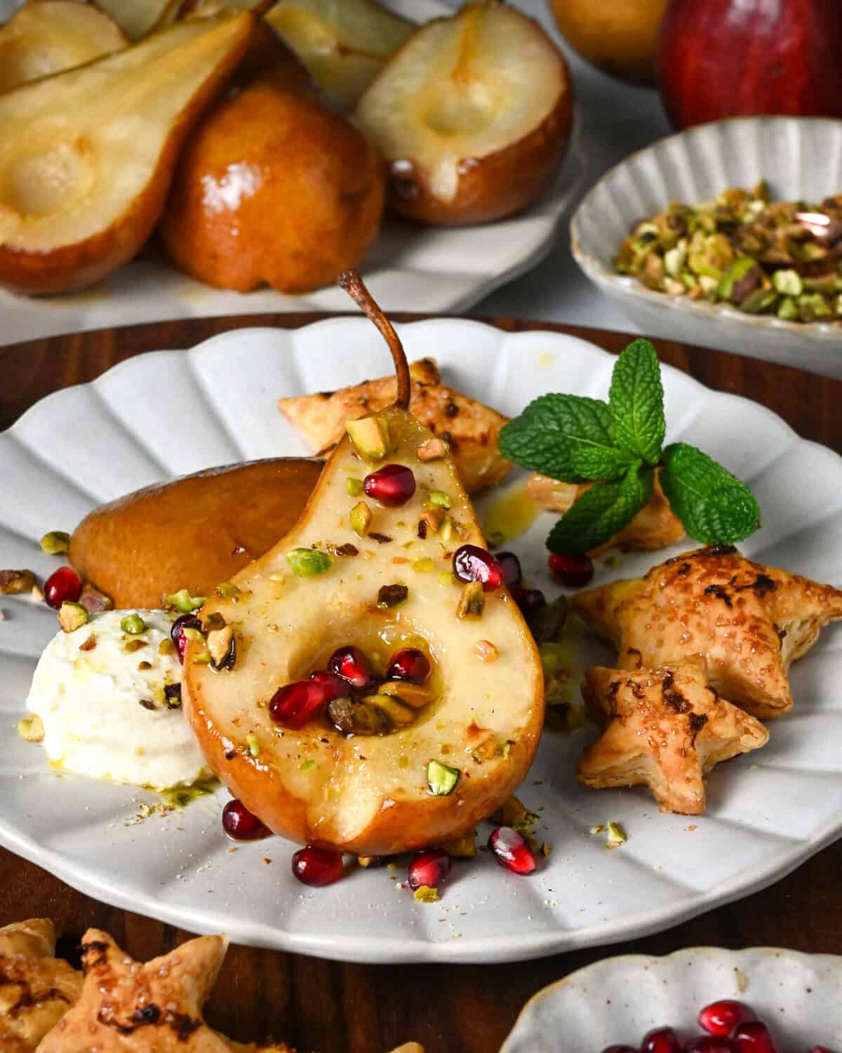 Honey roasted pear halves served with marscarpone, pistachios, puff pastry stars, mint and pomegranate arils.