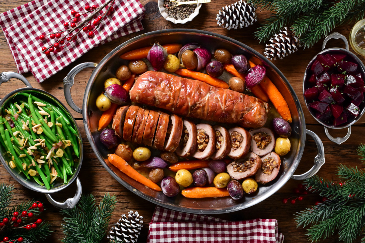 Two Prosciutto Wrapped Pork Tenderloin Stuffed with Figs & Brie served with roasted vegetables and garlicky rapini.