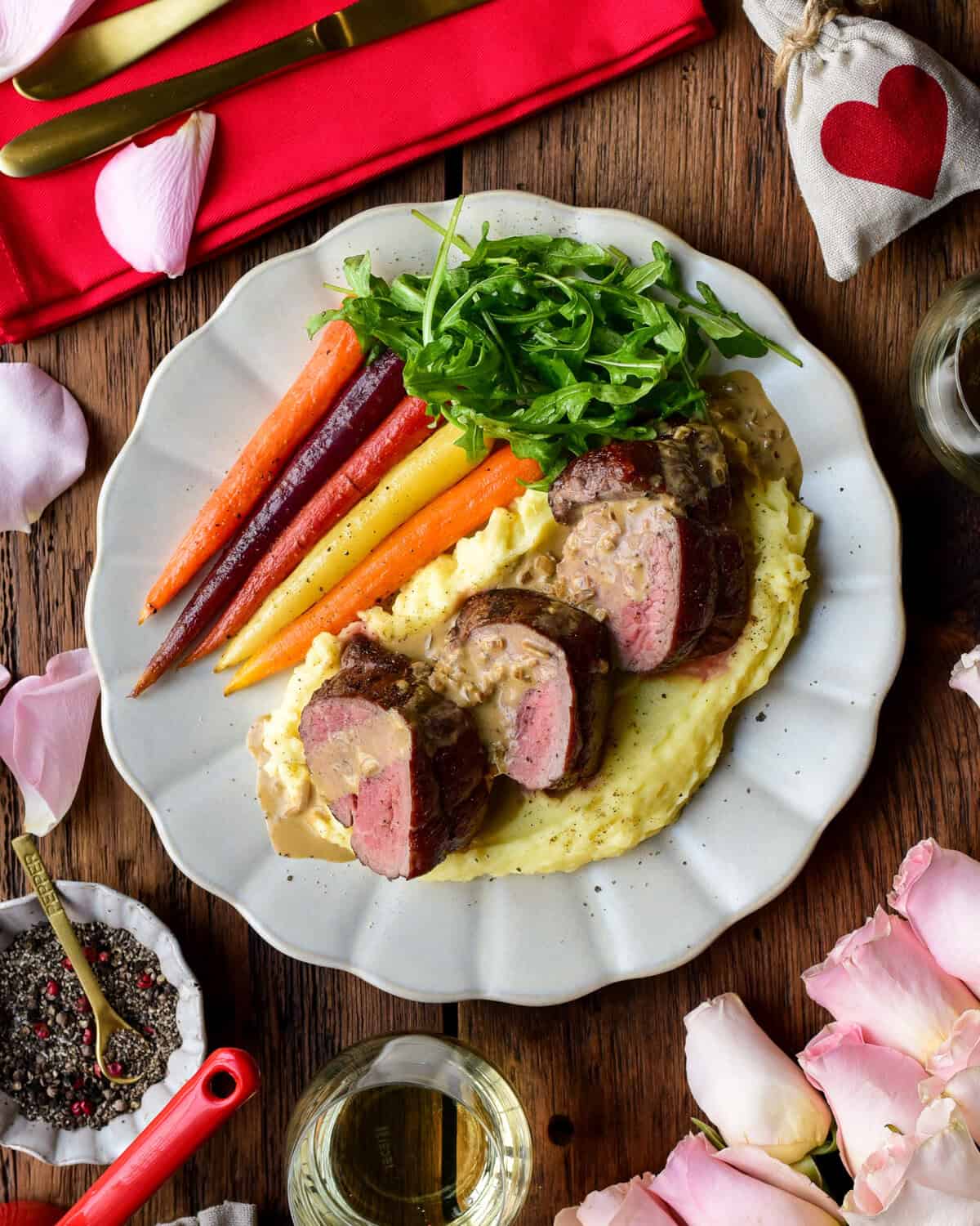 Three medallions of reversed seared veal tenderloin served with a Dijon Cognac sauce, potato puree, carrots and arugula for a Valentine's Day recipe.