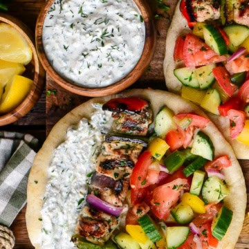 A bowl of creamy whipped feta tzatziki served with a chicken souvlaki pita.
