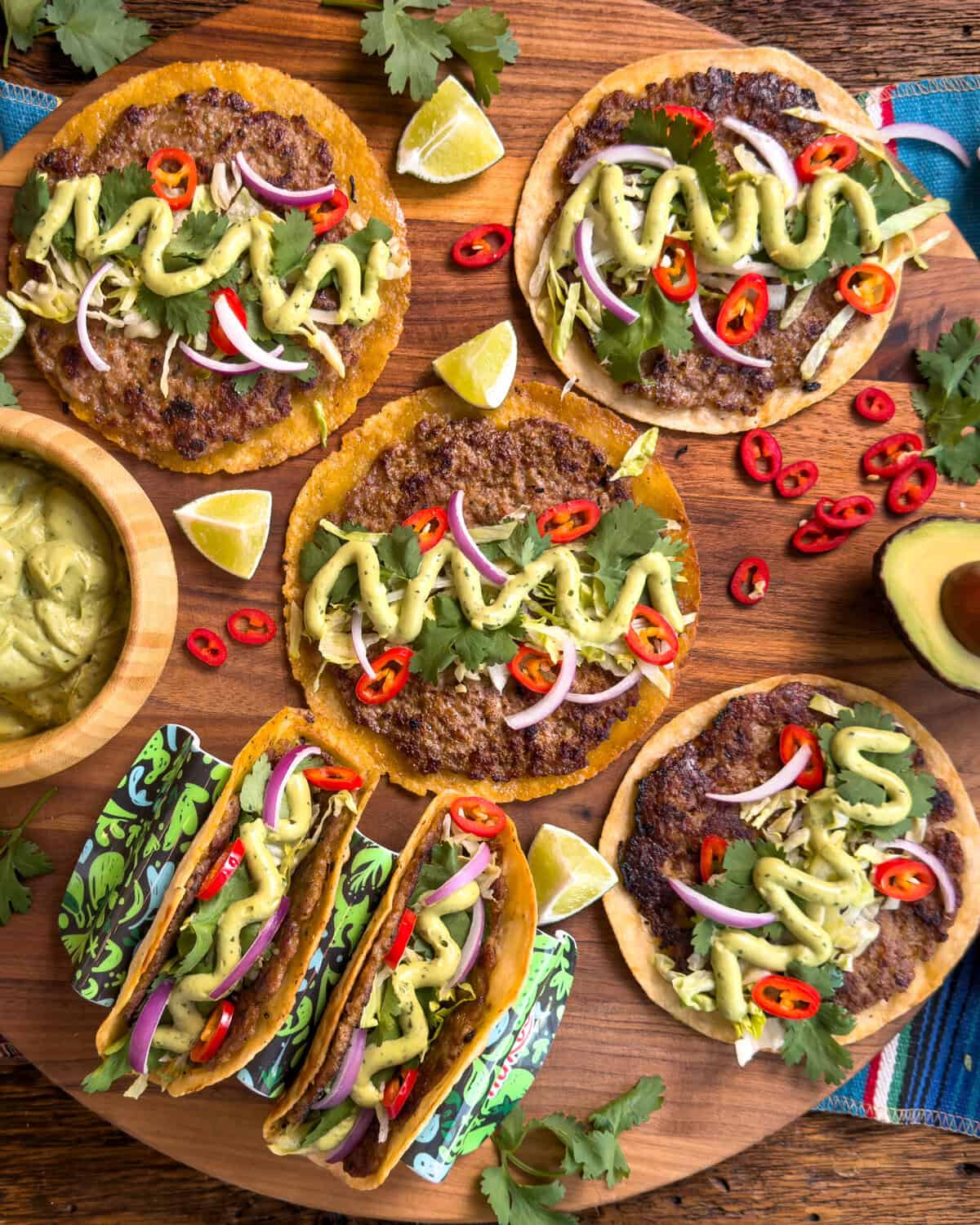 A platter of pork smash tacos with all the fixings and extra toppings on the side.
