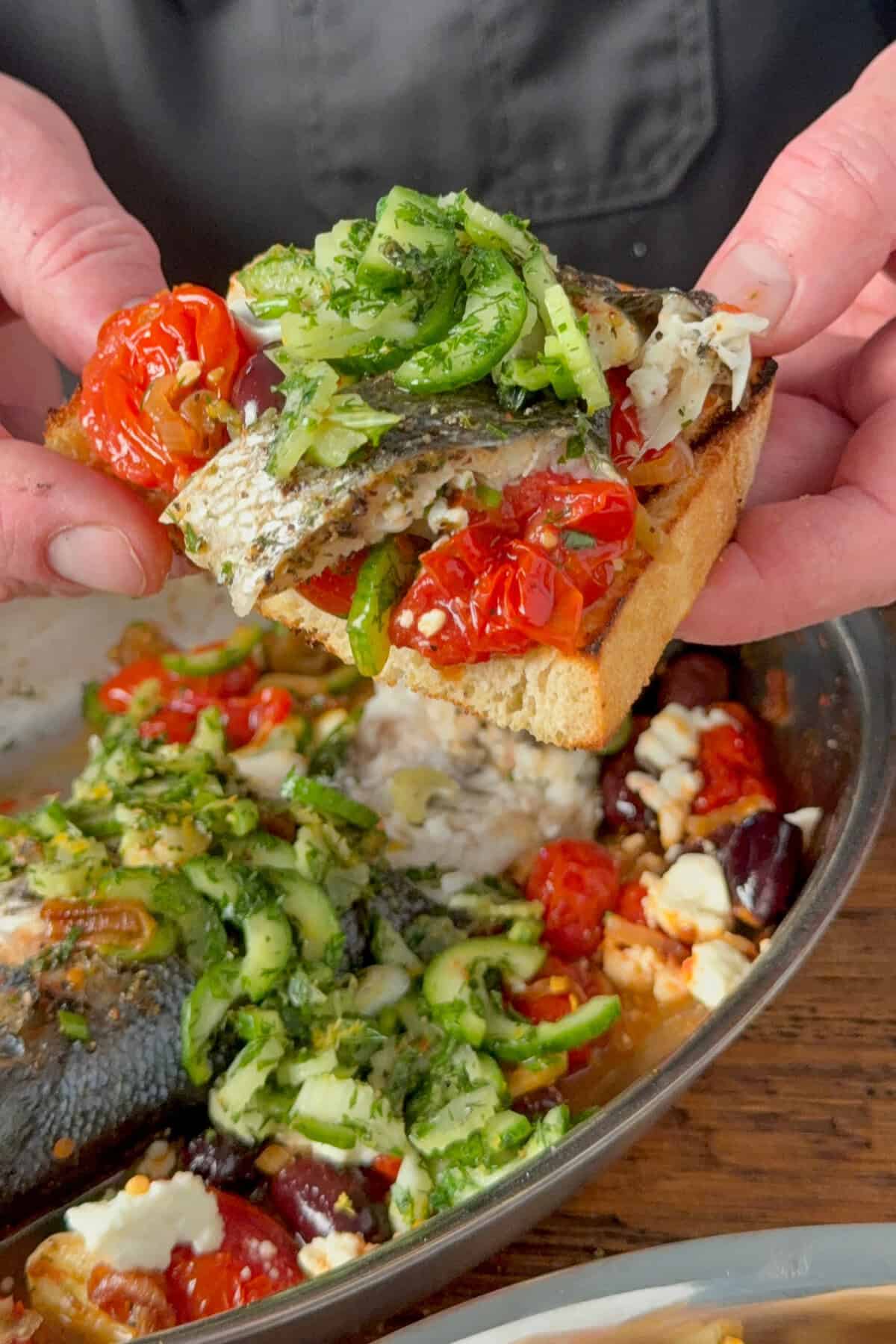 Greek Style Whole Roasted Branzino with Tomatoes & Feta on toasted sourdough.