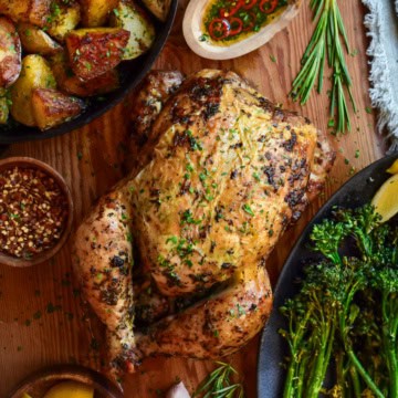 A whole rotisserie chicken served with golden duch fat potatoes and charred broccolini.