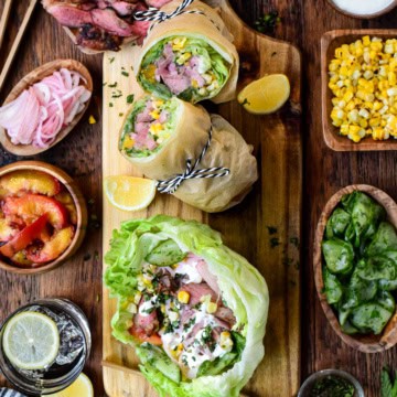 Freshly prepared wraps with vibrant ingredients, served with side dishes including corn, pickles, and salad at Zimmy's Nook. Perfect for a healthy, flavorful meal.