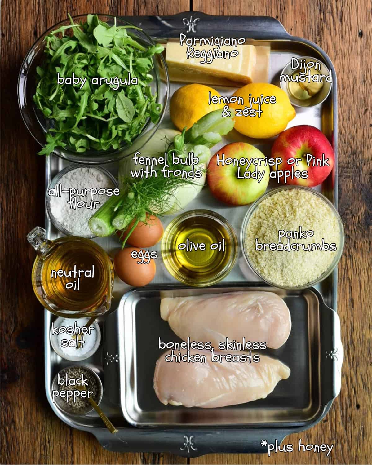 Ingredients for Crispy Chicken Milanese with Apple Fennel Salad including chicken breasts, baby arugula, honeycrisp apples, fennel bulb, lemon juice, Dijon mustard, eggs, olive oil, bread crumbs, and.