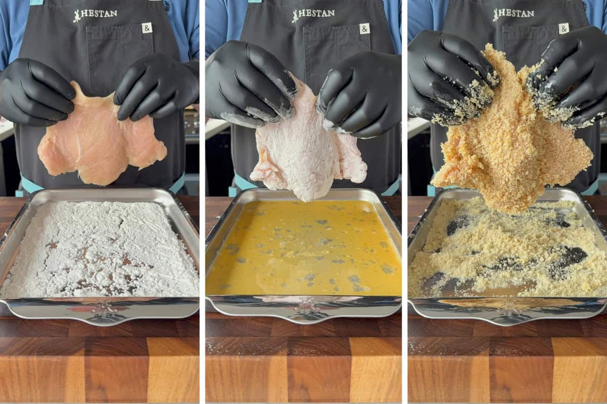 A chicken cutlet getting dredged through three breading stations: flour, egg and panko.