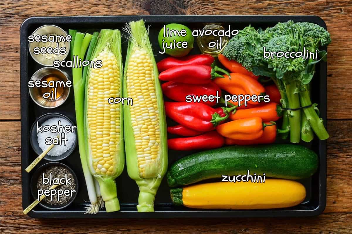 Ingredients laid out and labelled on a sheet pan for a market vegetable medley recipe.
