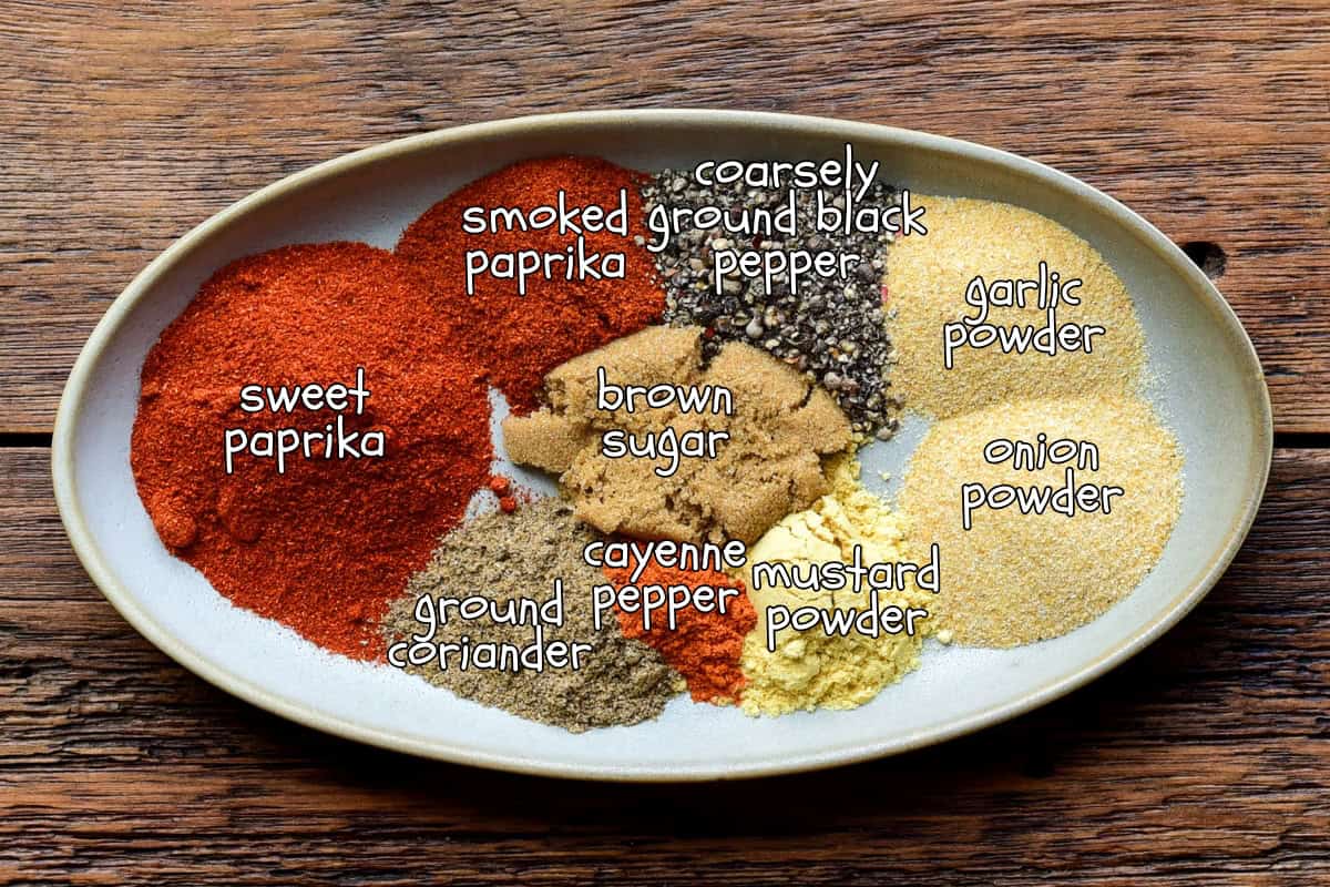 An oval dish with piles of spices for a pulled pork rub recipe.