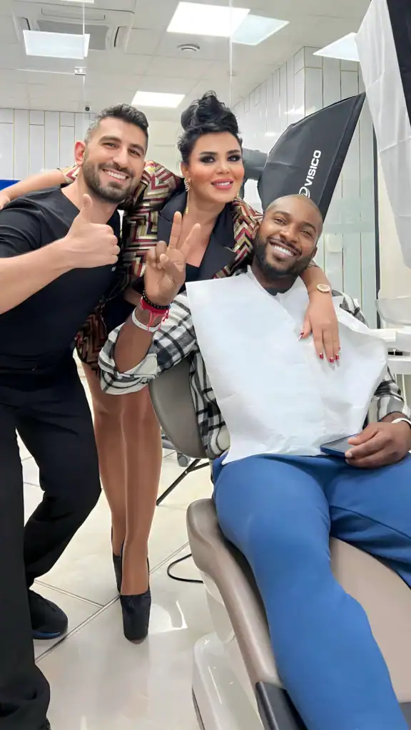 Aslı Tarcan avec un patient souriant et un membre de l’équipe dans la salle de soins dentaires