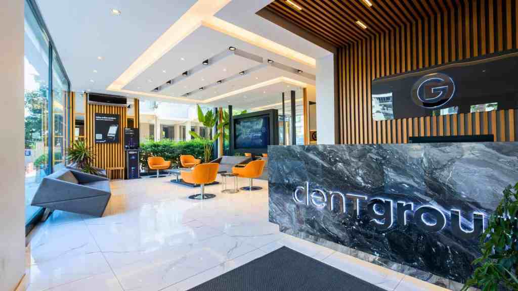 Reception lussuosa di DentGroup con bancone in marmo e sala d'attesa moderna dal design premium