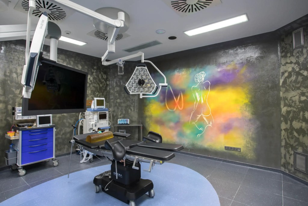 Salle d’opération moderne de la clinique Estetik International avec équipement médical avancé et mur artistique coloré