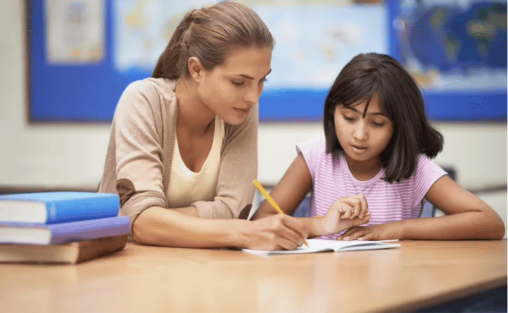 Teacher and student collaborating in a classroom setting for inclusive education.