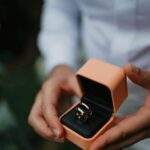 elegant ring in box held by person in white shirt