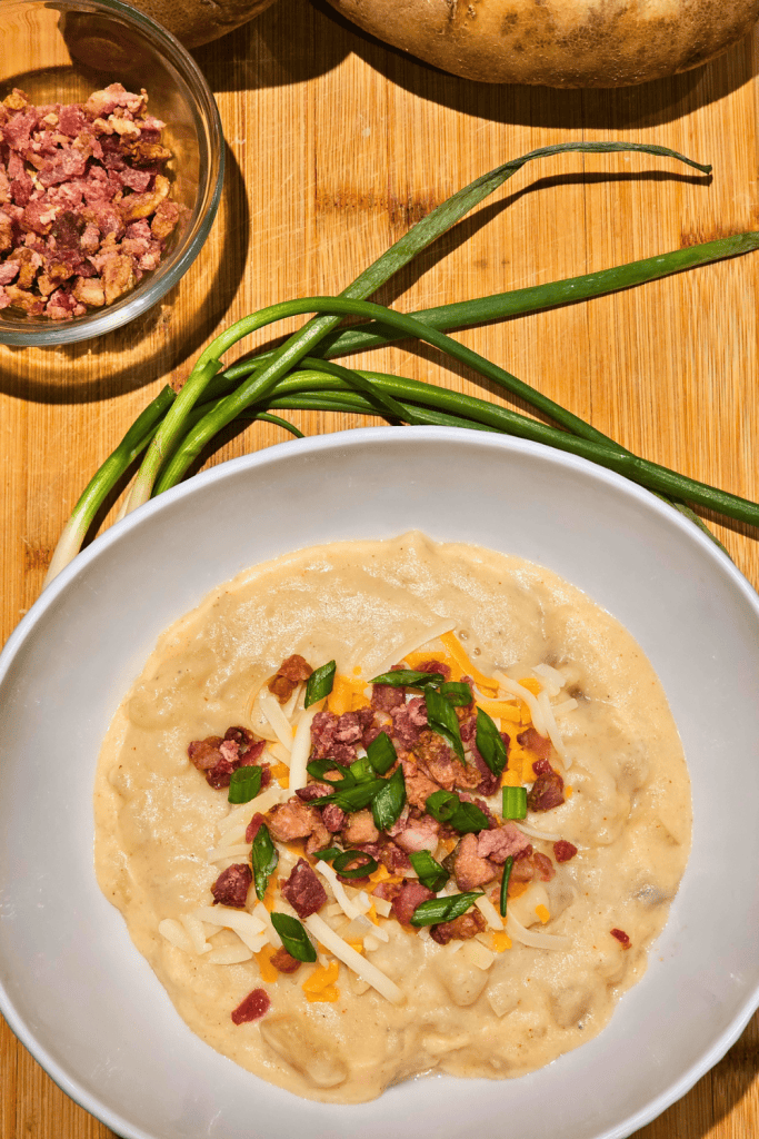 Delicious crockpot potato soup topped with cheese, bacon, and green onions, perfect for cozy comfort.