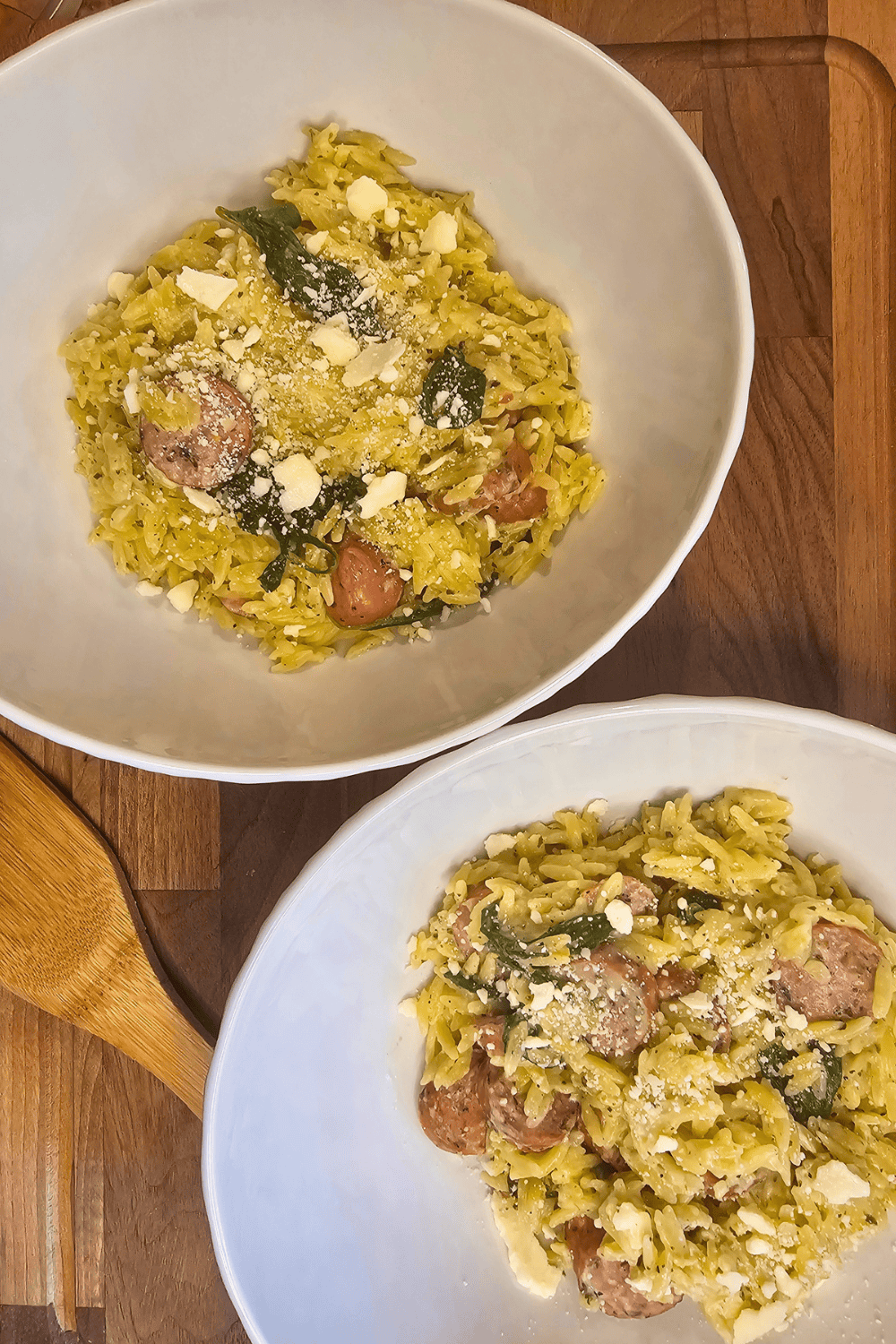 Creamy garlic herb sausage orzo with fresh herbs and grated cheese, perfect for a comforting meal.