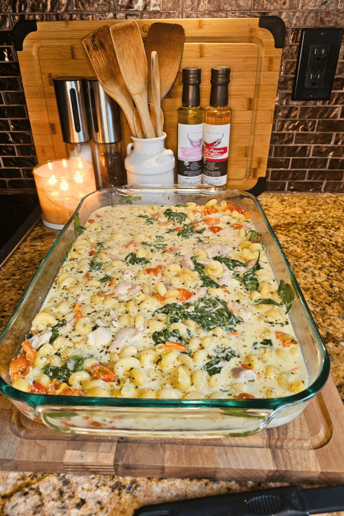 Delicious creamy garlic and herb tomato spinach pasta in a glass baking dish. Perfect comfort food w.
