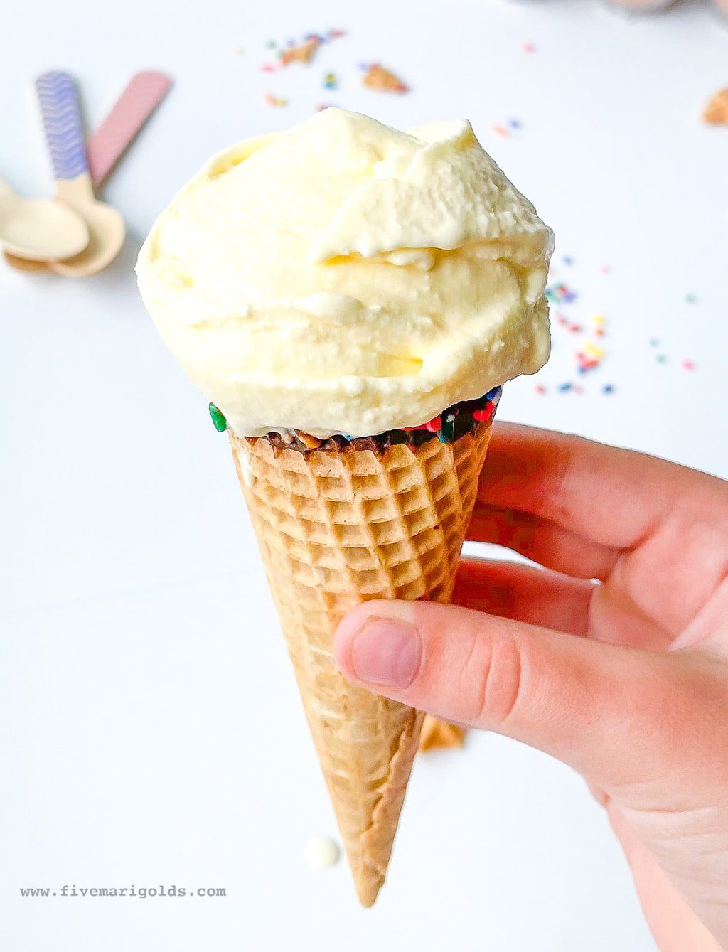 Child's hand holding marshmallow vanilla ice cream cone
