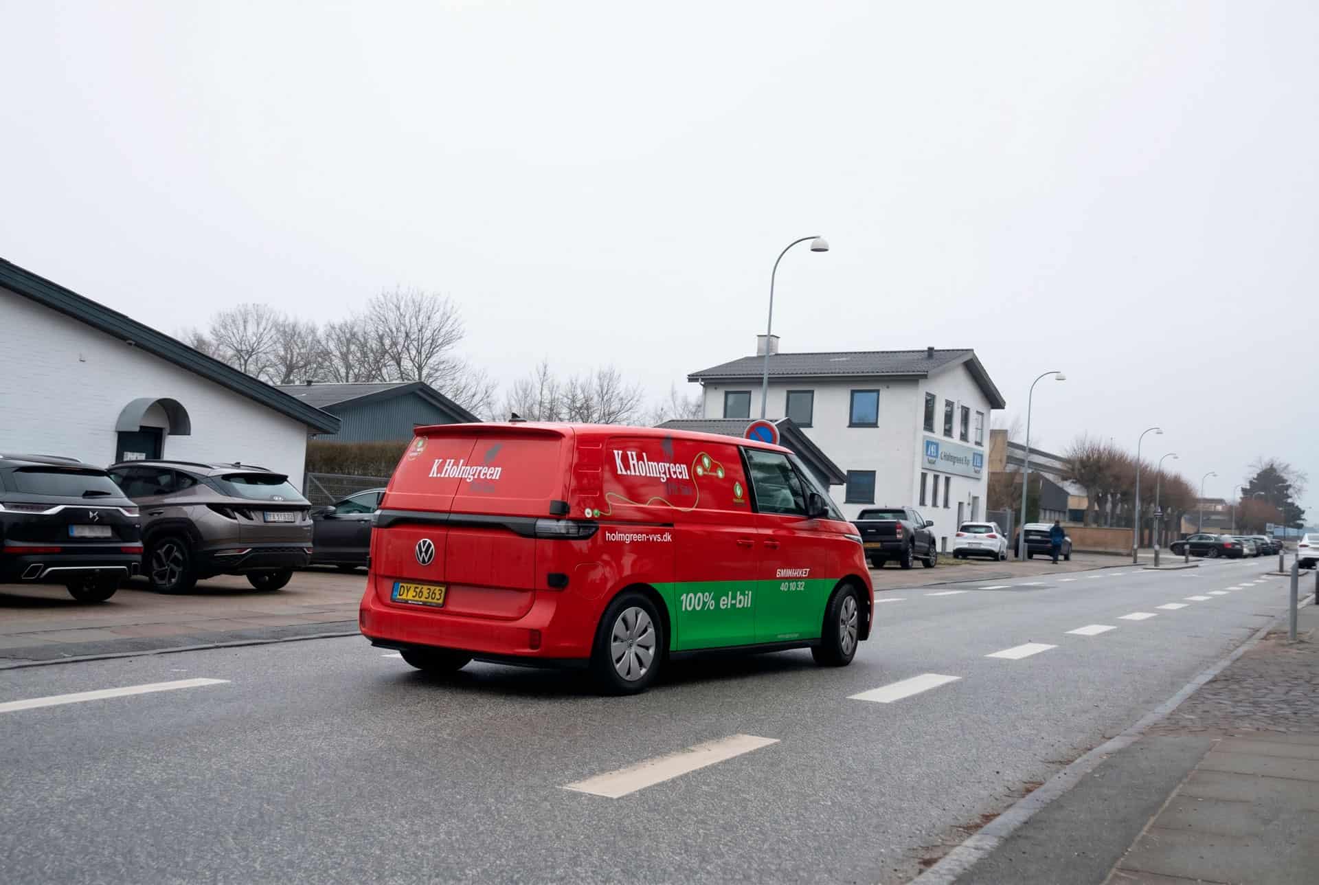 Parkeret rød K. Holmgreen & Søn varevogn set fra en anden vinkel på vejen.