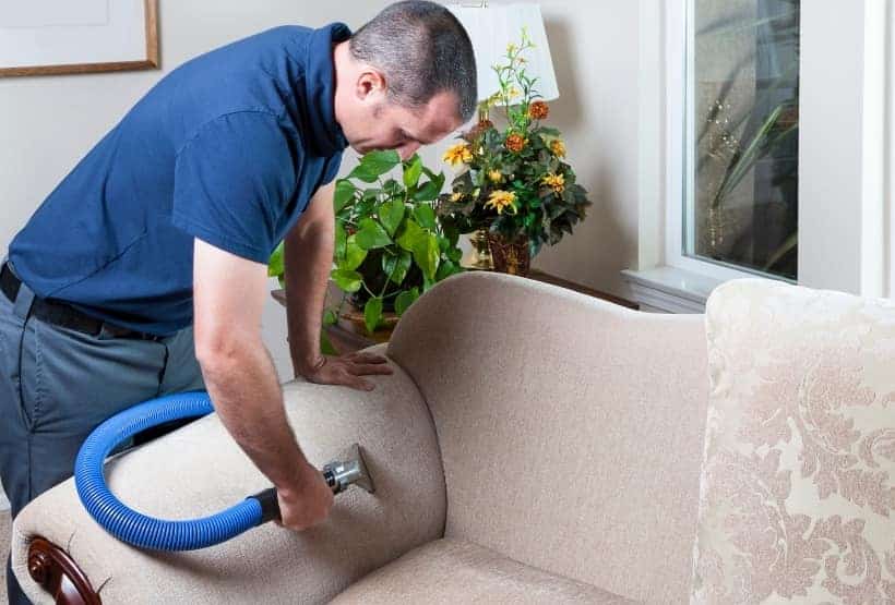 clean fabric sofa with vacuum cleaner