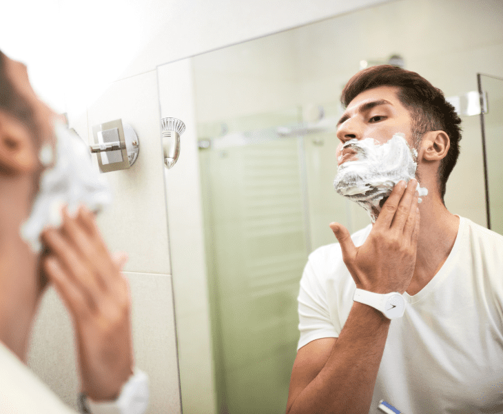 man shaving using mirror