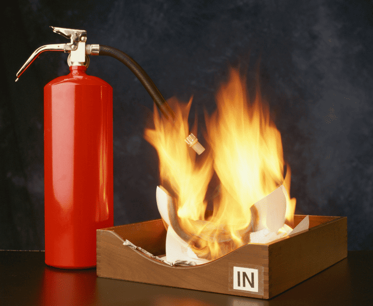 fire extinguisher beside burning paper