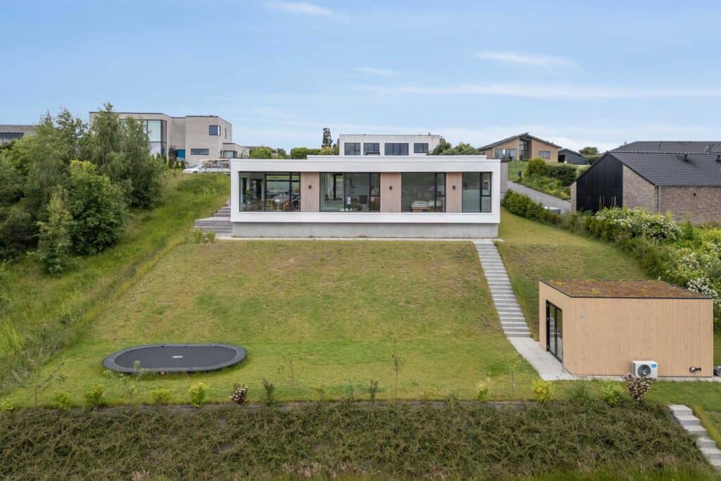 Hvid funkisvilla smukt integreret på grøn grund.