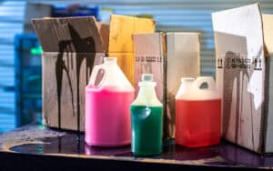 messy, unlabeled cleaning product bottles that are not stored or handled properly