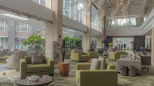 Bright, welcoming modern hotel lobby with sofas and a plant, an example of a space that benefits from air care solutions