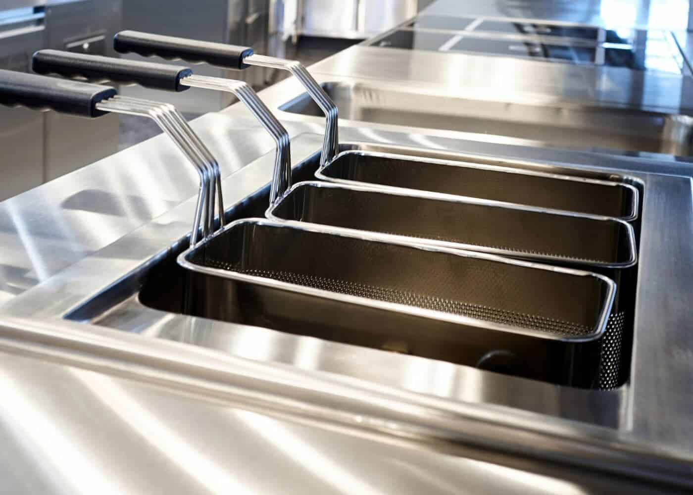 Stainless steel commercial deep fryer baskets in kitchen