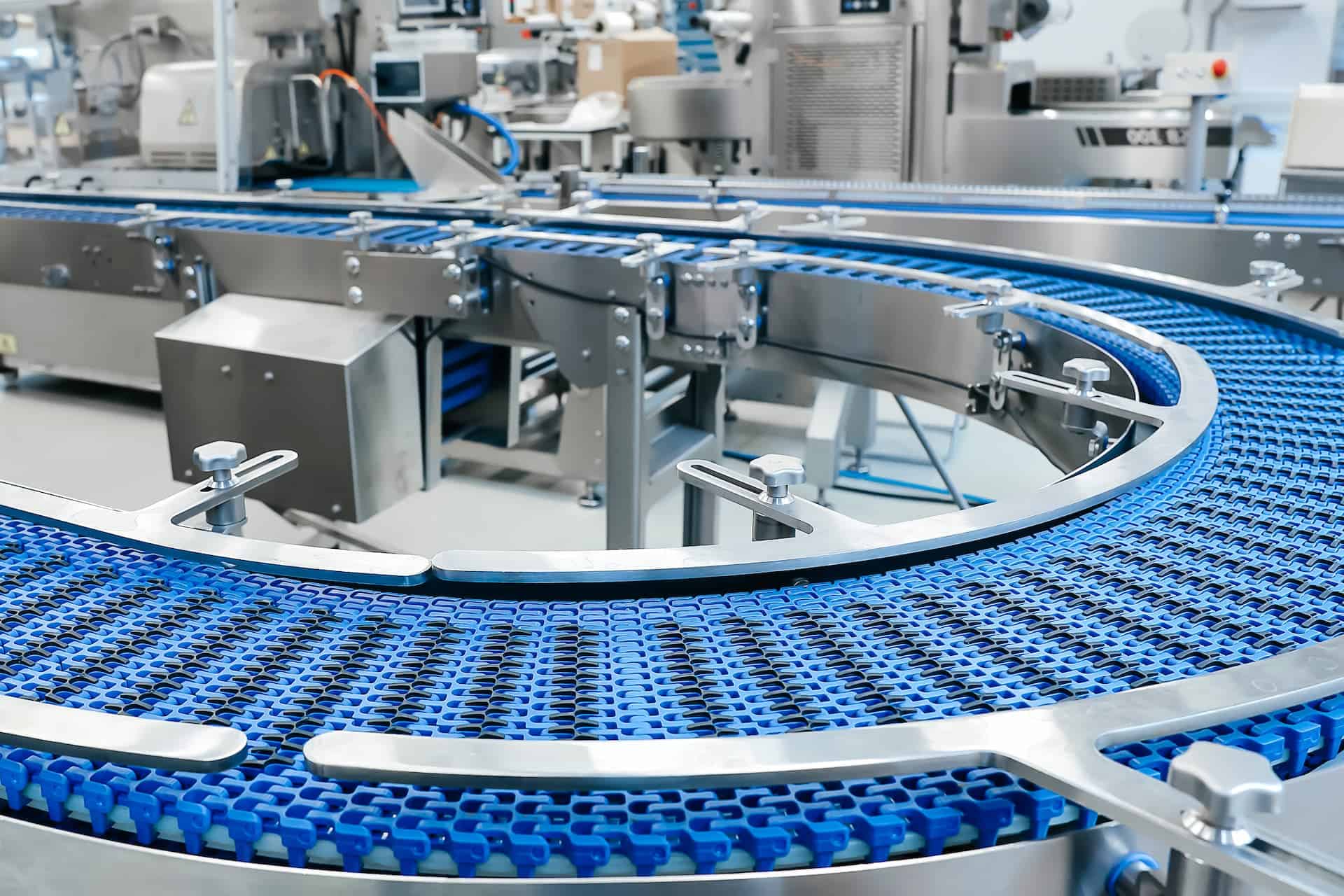 Curved industrial conveyor belt in manufacturing facility
