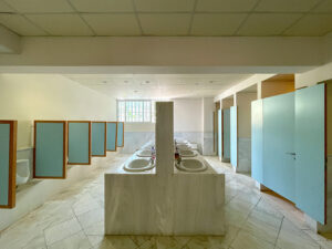 Commercial restroom with sinks and stalls, an example of a space that benefits from restroom odor control