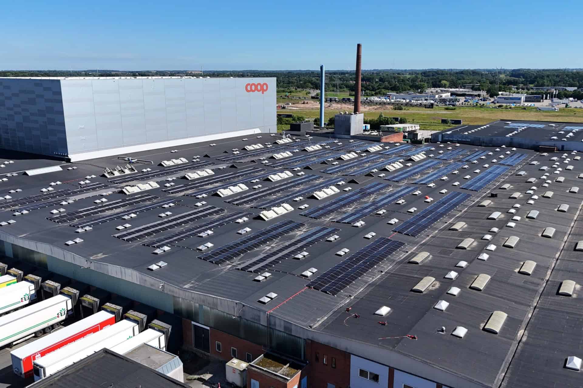 Solcellepaneler på tagene af et stort lagerbygning ved Coop.
