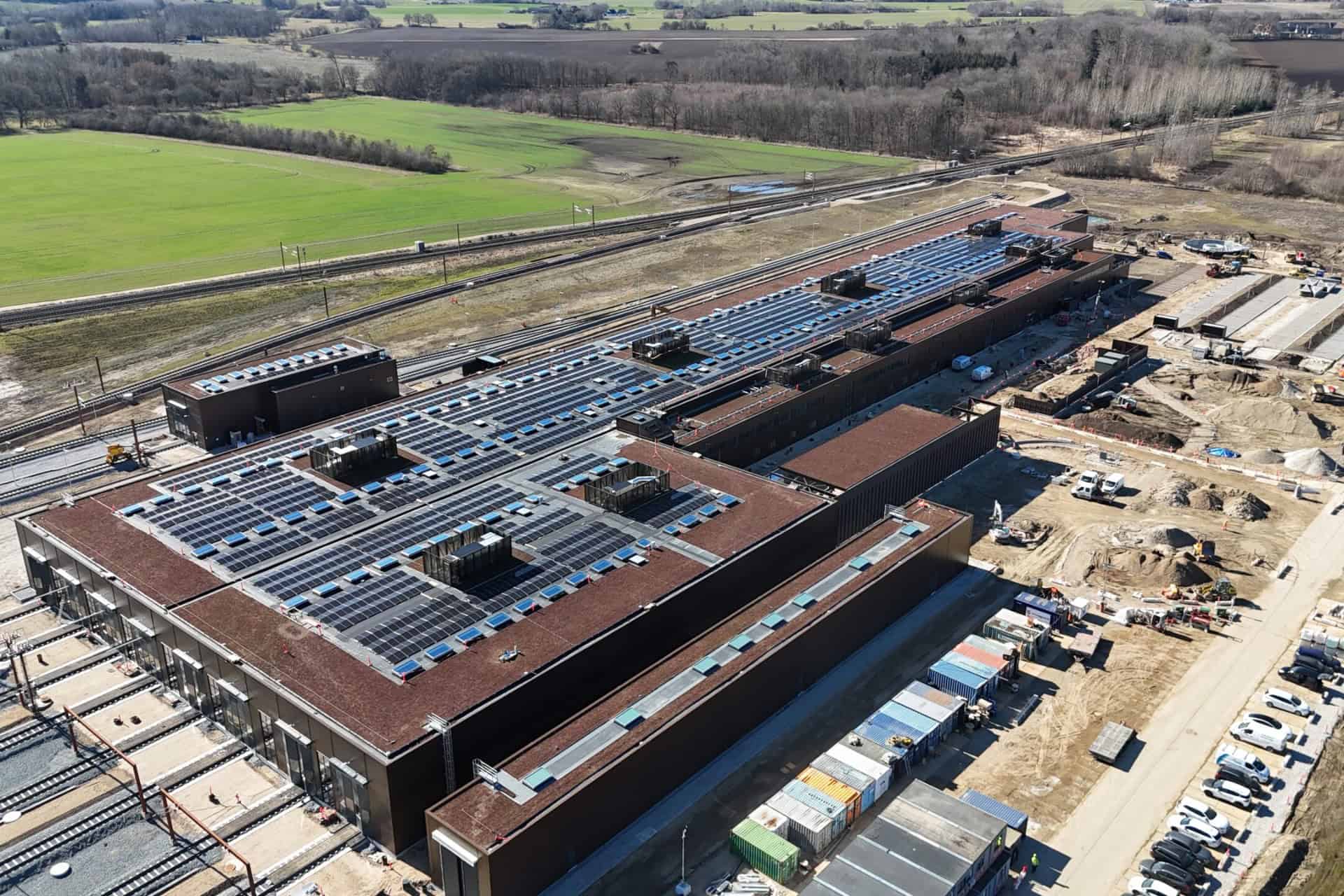 Stort solcelleanlæg installeret på tagene af industriel bygning.
