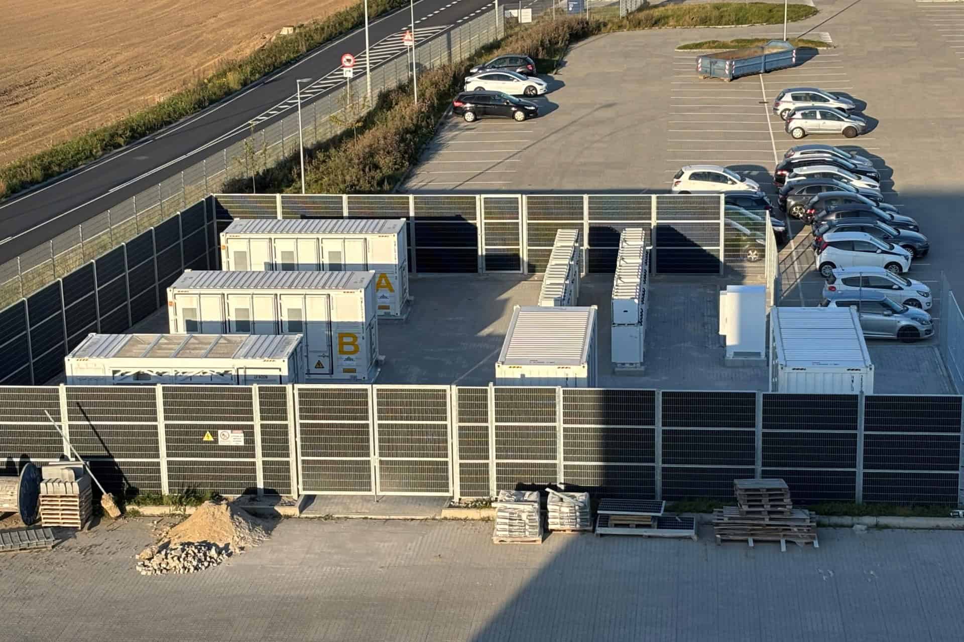 Solcelleanlæg installeret på en parkeringsplads med biler.