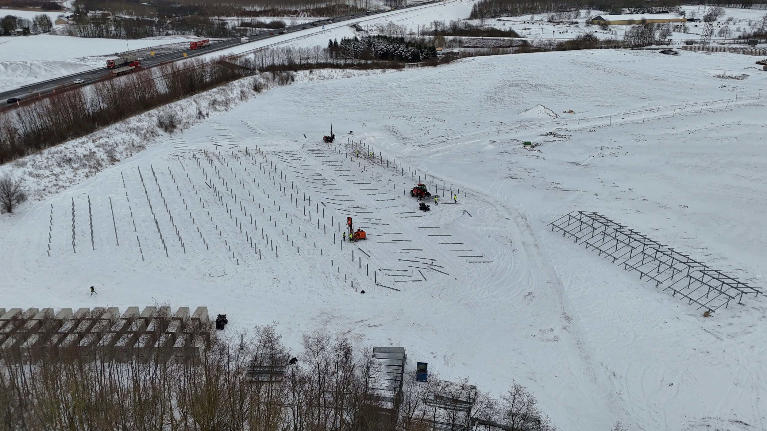Solcellepaneler installeret i sneet landskab.