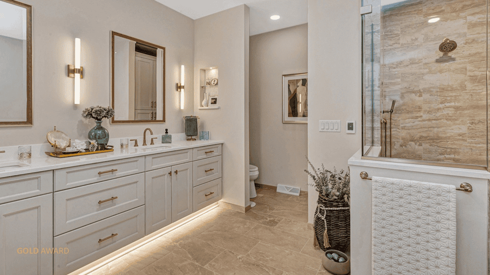 Bathroom with dual vanity, private toilet area, and walk-in shower. All neutral tones, creams, and beige.