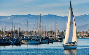 A sailboat cruises the channel at sunset
