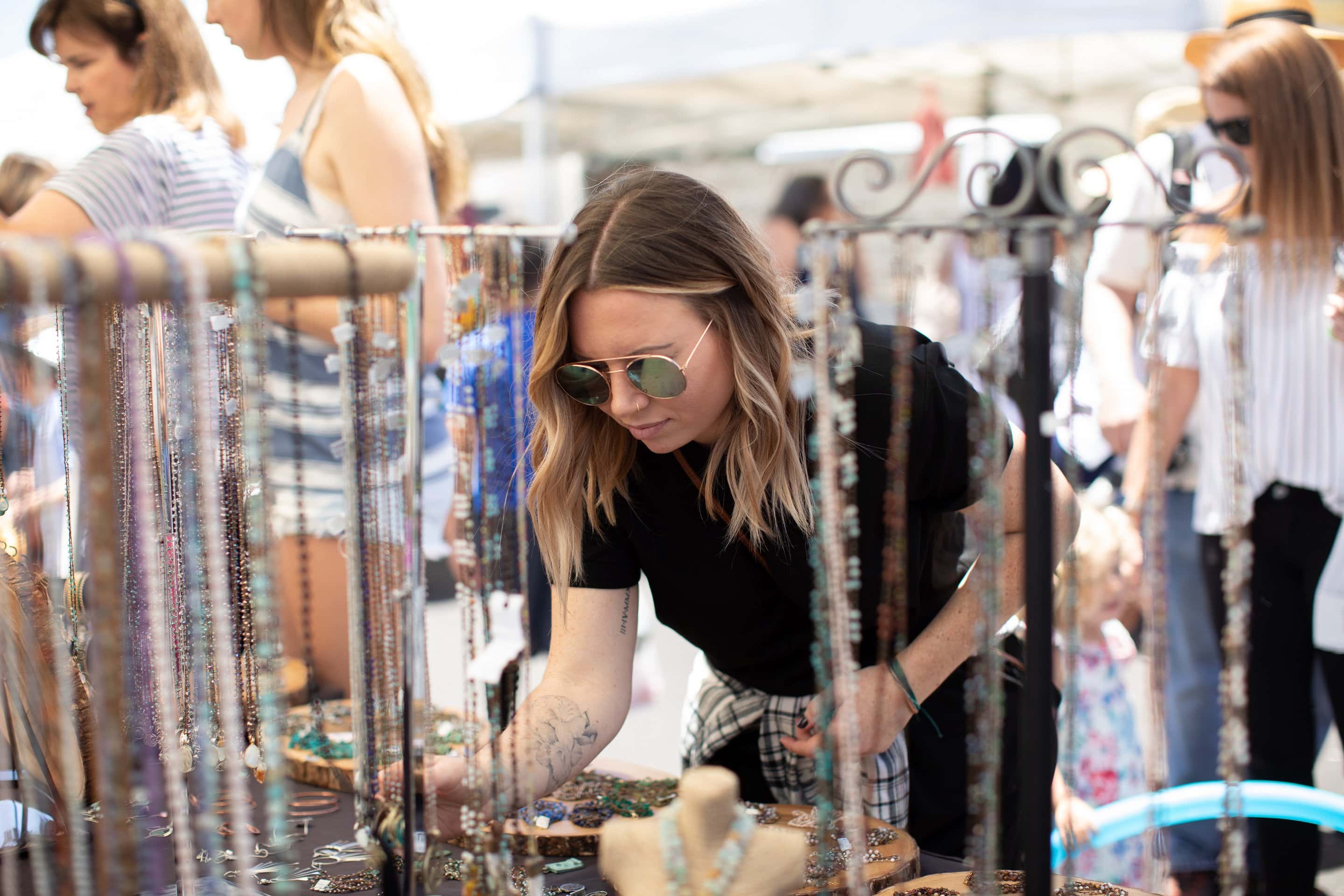 A woman looks at necklaces during the Farmers Market Holiday Marketplace