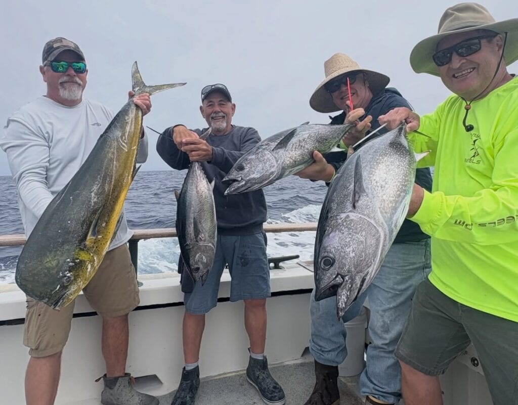 Group of four men holding large fish on a boat at Channel Islands Harbor.
