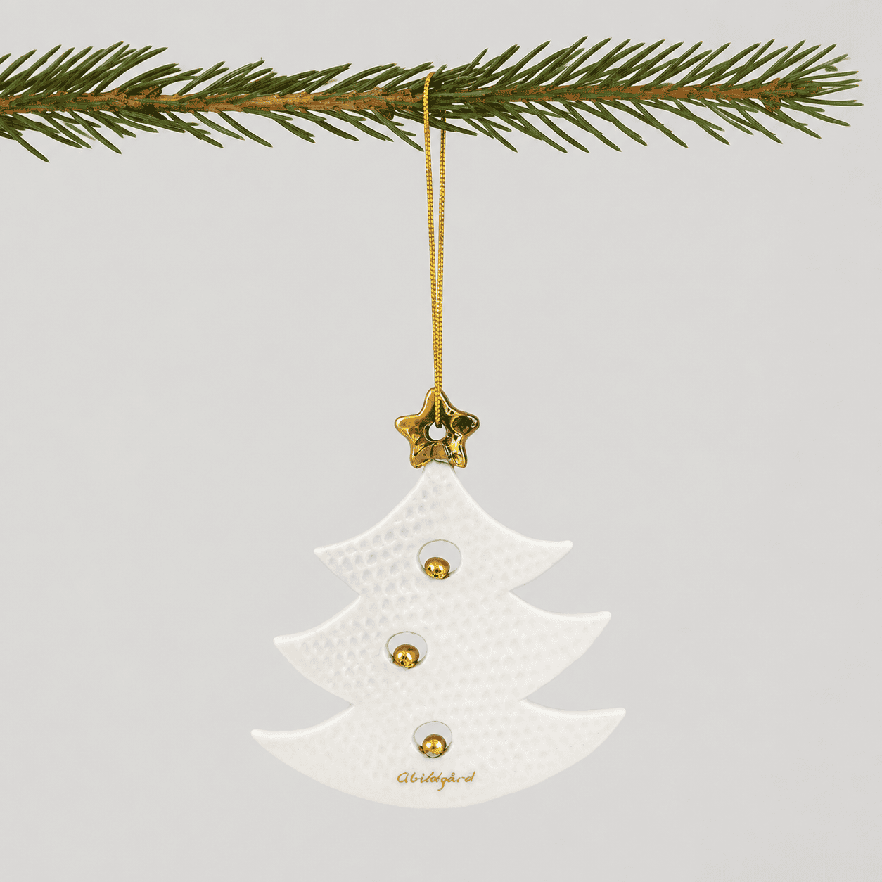 Keramisk juletræ ornament med gulddetaljer og stjerne.