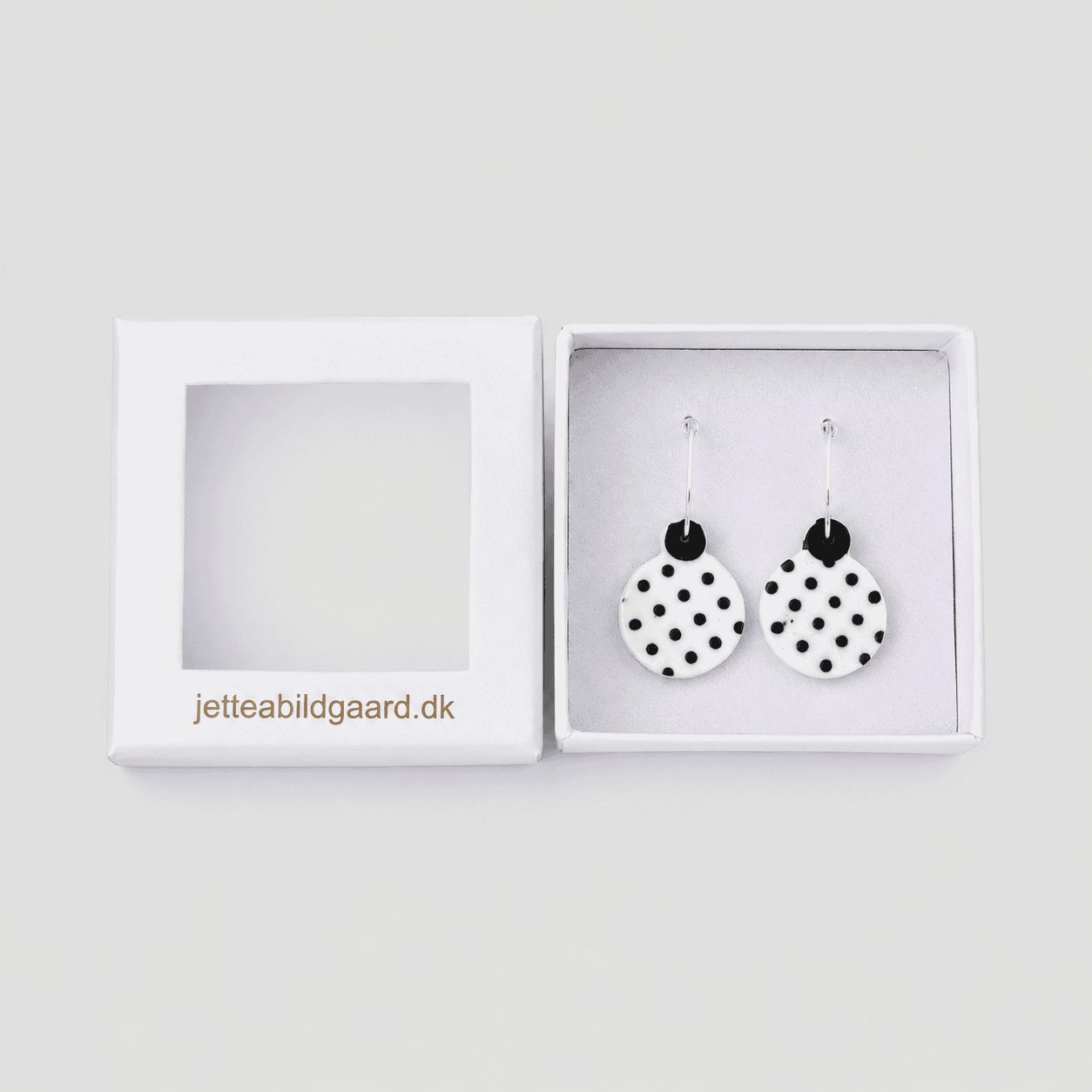 Unikke keramiske øreringe med polka dot design i sort og hvid.