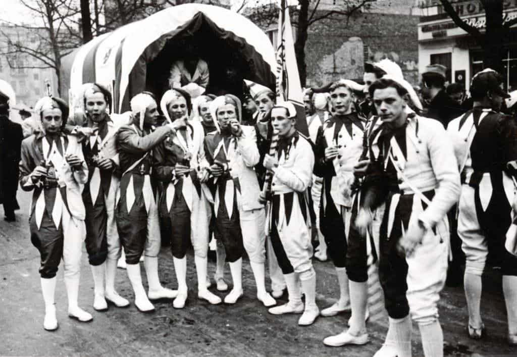 Historisches Foto der KG Uhu in Harlekin-Kostümen beim Karnevalsumzug