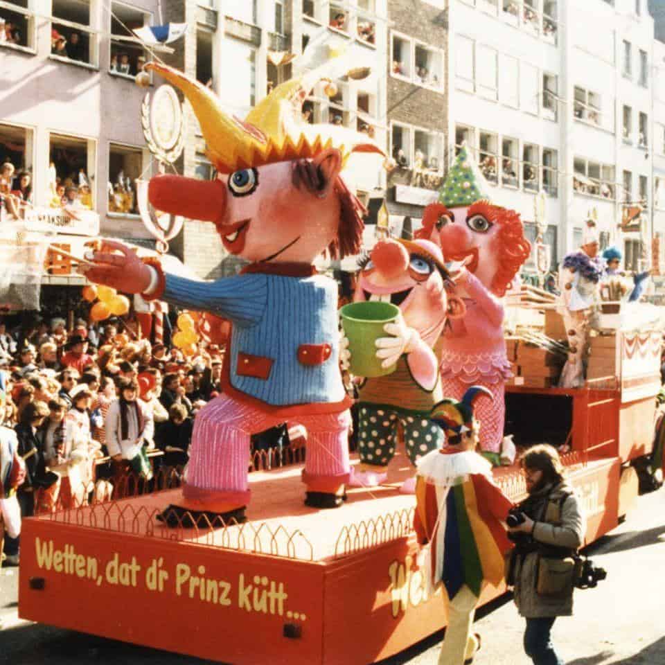 Festwagen 1982 mit großen Puppenfiguren, Schriftzug „Wetten, dat d'r Prinz kütt...“