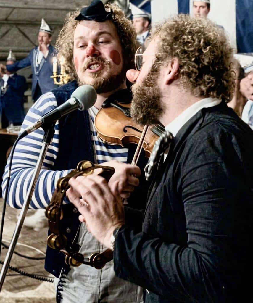 Zwei Musiker der Band De Höhner singen und spielen Geige und Tamburin auf der Bühne