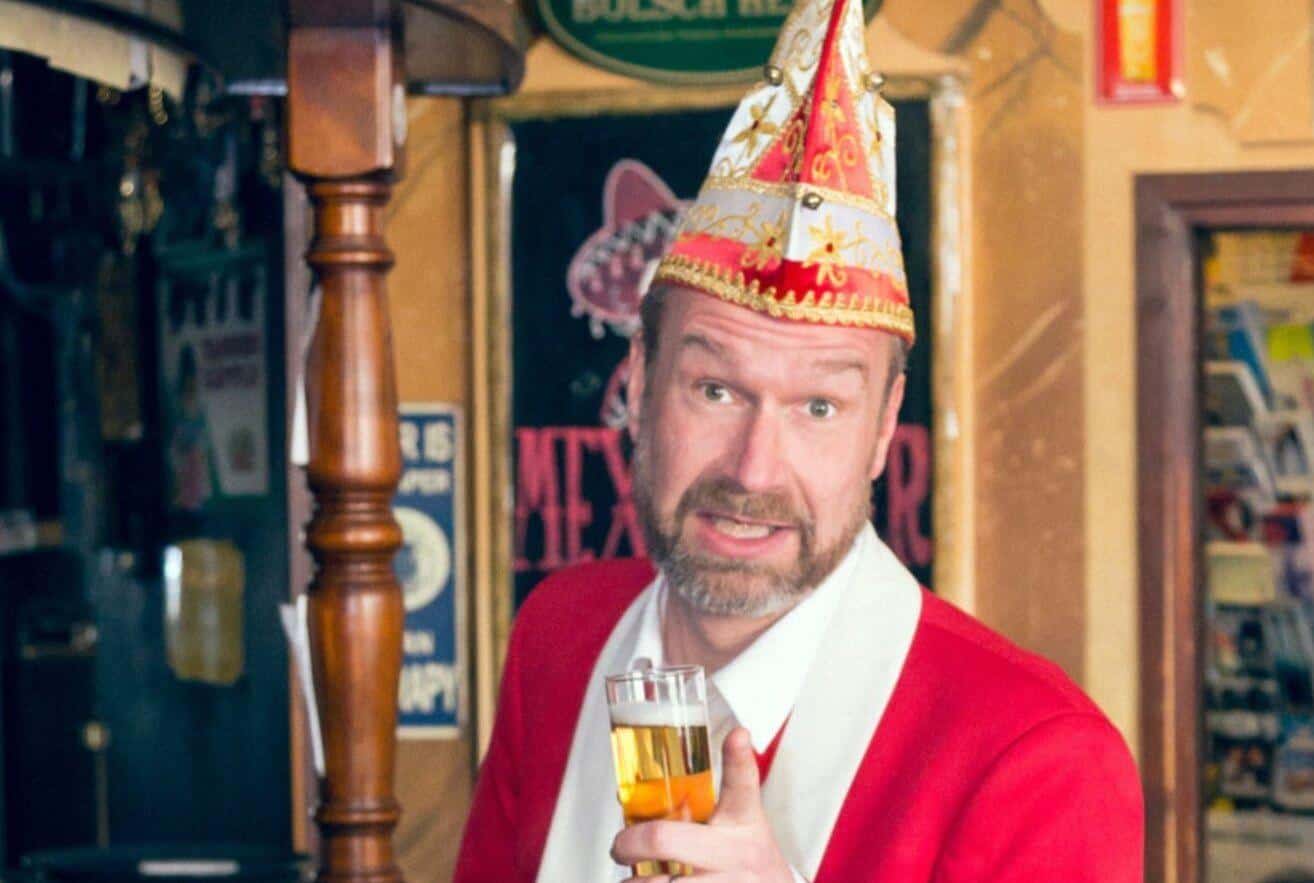 Volker Weininger mit Narrenkappe und Kölschglas in einer Kneipe