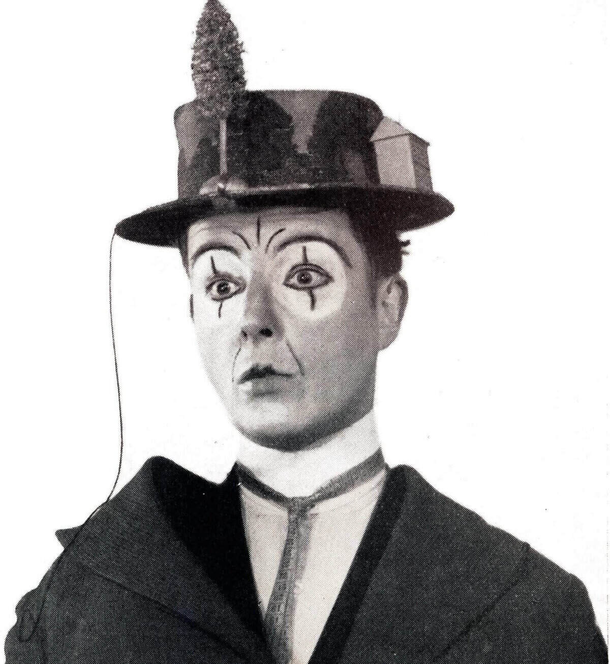 Historisches Foto einer Person in weißer Pierrot-Schminke mit Zylinder