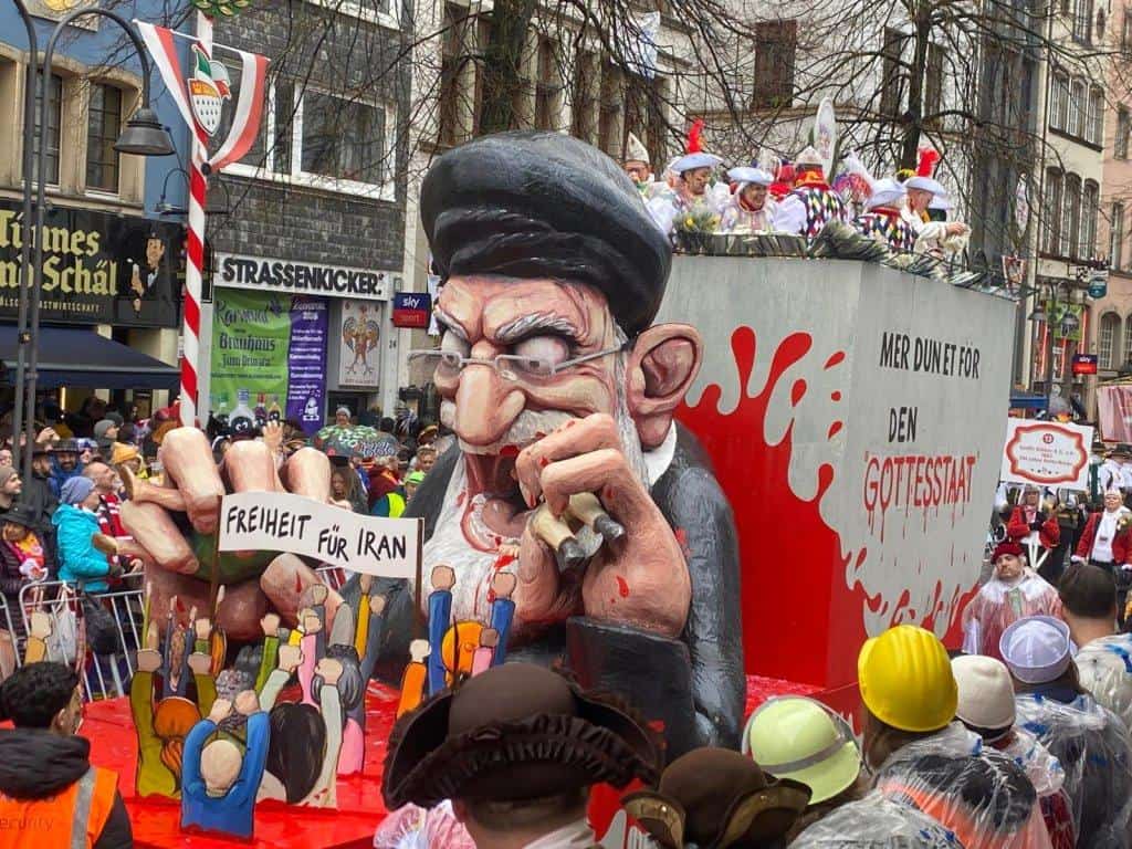 Rosenmontagswagen mit satirischer Karikatur eines Mullahs und Protestschildern „Freiheit für Iran"