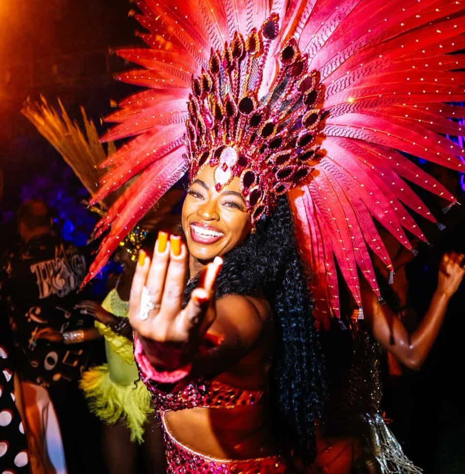 Bunt kostümierte Jecke mit prächtigem Federkopfteil beim Karneval.