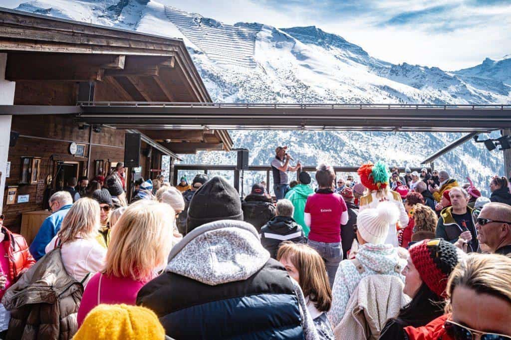 Menschen bei der Kölsche Woche in Hintertux mit Bergpanorama im Hintergrund.