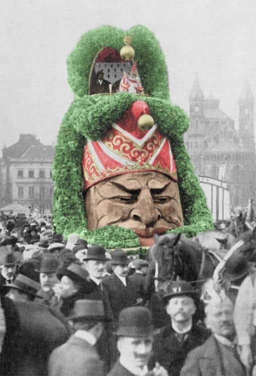 Traditionelle Karnevalsmaske mit großem Kopf und buntem Hut in Köln.